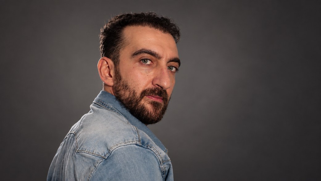 Matteo Freni, in arte Brake, ritratto in studio con la giacca di jeans su fondo grigio
